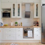 Белая кухня с холодильником цвета металлик