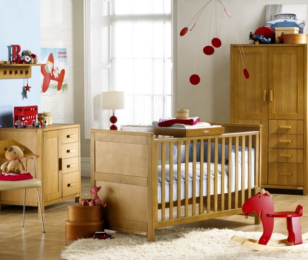 Детская комната с мебелью натуральных тонов и яркими красными элементами